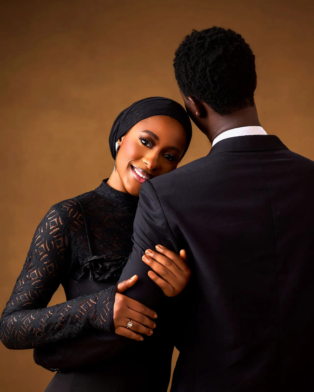 A newly engaged couple embracing and smiling